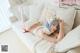 A woman laying on top of a white couch.