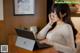 A woman sitting at a table using a laptop computer.