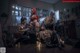 A group of people sitting on top of a wooden floor.