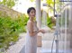 A woman in a white dress standing in front of a shower.