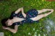 A woman laying on the ground in a field of flowers.