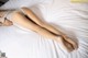 A woman laying on top of a white bed.