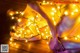 A naked woman laying on a wooden floor covered in lights.