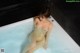 A naked woman sitting in a bathtub filled with water.