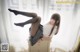 A woman sitting on top of a dresser with her legs up.