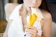 A woman is eating a banana with her mouth open.