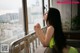 A woman sitting on a couch looking out a window.