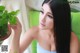 A woman with long black hair holding a potted plant.