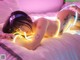 A woman laying on a bed covered in neon lights.